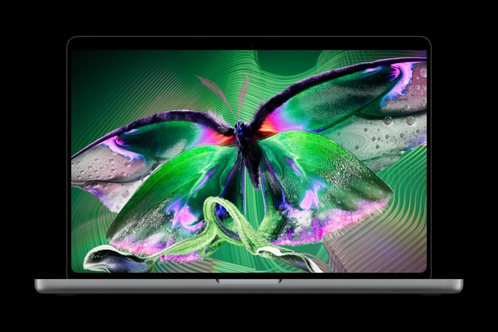 Close-up of a vibrant butterfly-inspired laptop display with neon greens and purples on a dark background.