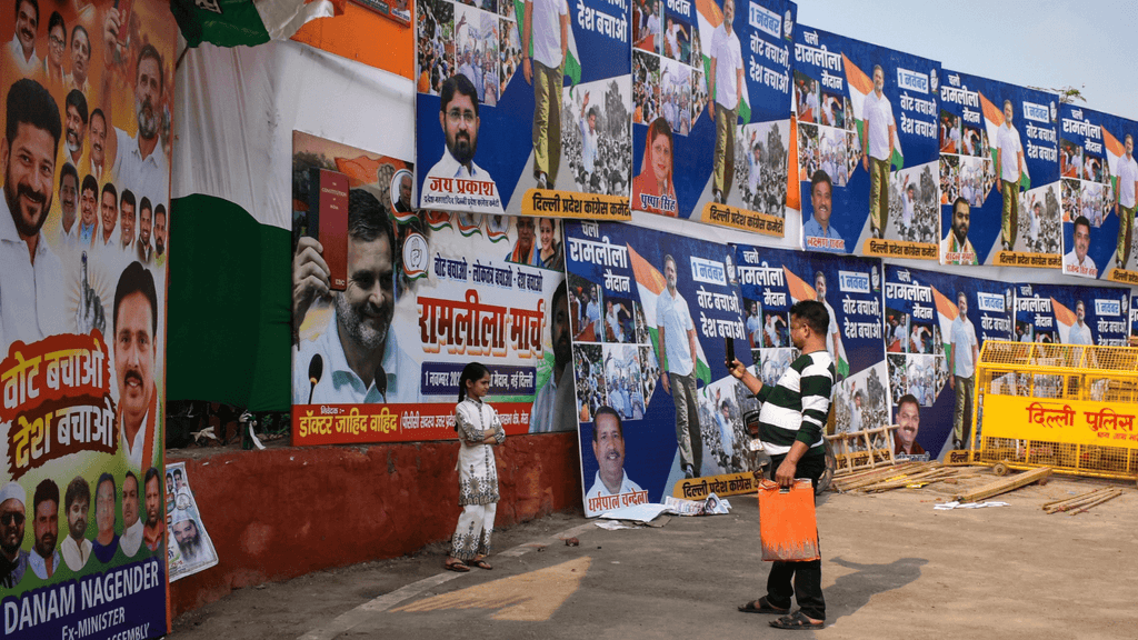 Crowded wall covered with political banners and posters during rally.