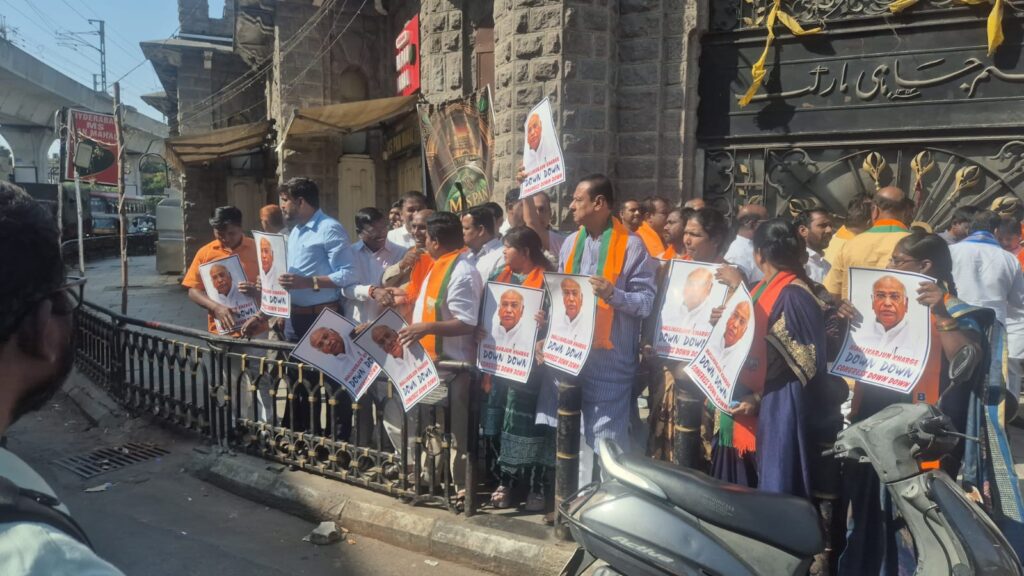 Protesters in Hyderabad hold posters featuring a political figure during a street demonstration.