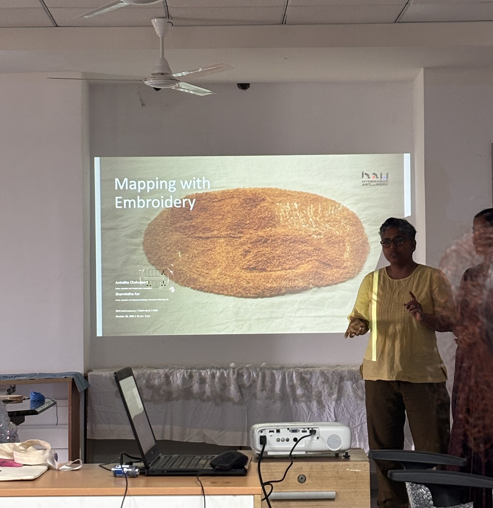 Instructor presenting 'Mapping with Embroidery' workshop on a projector screen in a seminar room.