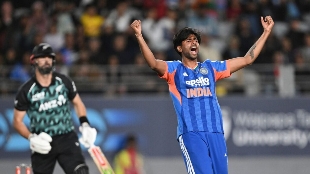 Cricketer celebrating with arms raised after a wicket in an India vs New Zealand match.